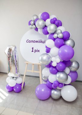 photo zone with an easel and a garland of balloons, an inscription; 