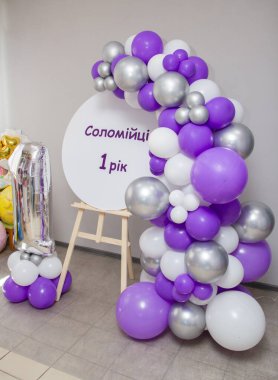 photo zone with an easel and a garland of balloons, an inscription; 