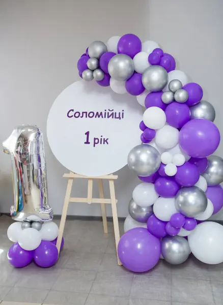 photo zone with an easel and a garland of balloons, an inscription; 