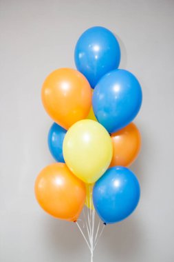 Beyaz arka planda bir grup sarı ve pembe helyum balonu