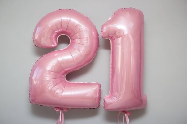 Beyaz arkaplanda 21 numaralı pembe balonlar