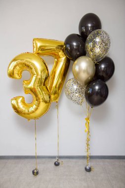 Beyaz zemin üzerinde 37 adet altın rengi balon