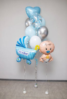 Doğum hastanesinden taburcu olmak için mavi balonlar, mavi bebek arabası, bebek balonu figürü.