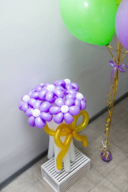 Parlak balonlar ve tatil için balonlardan bir buket mor papatya.