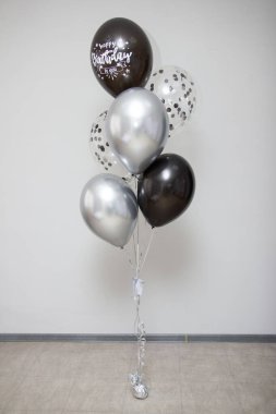 Beyaz zemin üzerinde siyah ve gümüş krom helyum balonları bileşimi