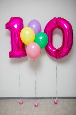 Pembe 10 numaralı balonlar ve beyaz arka planda parlak helyum balonları.