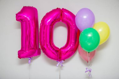Pembe 10 numaralı balonlar ve beyaz arka planda parlak helyum balonları.