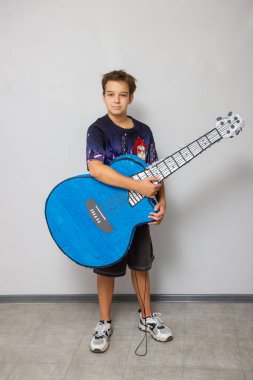 beyaz arka planda çocuk ve büyük gitar şekilli pinata