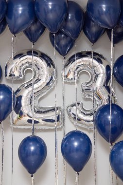 23 numaralı gümüş balon ve bir buket mavi lateks helyum balonu.