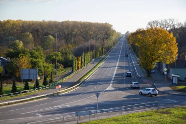 a road going into the distance among autumn trees in Chernigov clipart