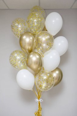 Bir buket altın, beyaz ve berrak konfetili balonlar