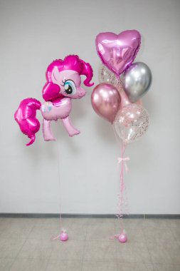 Pembe balonlar ve pembe midilli heykelcikler.