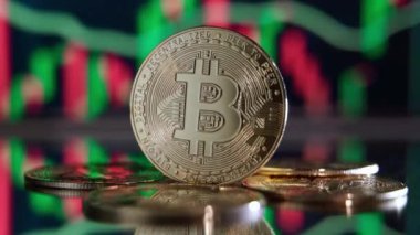 Golden bitcoin standing on mirror surface reflecting background with crypto chart with green and red candlesticks. Cryptocurrency trading market concept