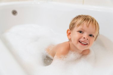 Köpükle banyo yapan sevimli küçük bir çocuğun portresi. Boşluğu kopyala