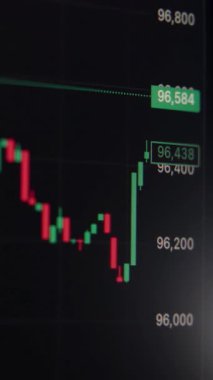 Yeşil ve kırmızı şamdanların yer aldığı dijital ticaret ekranının yakın çekimi, kripto para birimindeki piyasa dalgalanmalarını yansıtıyor ve ekonomik eğilimler ve yatırımcı faaliyetleri arasında hisse senetleri. Dikey video