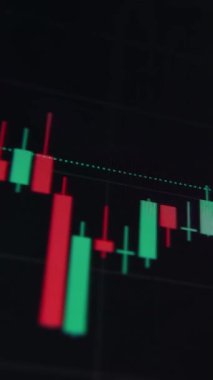 Borsa dalgalanmalarını, yatırım eğilimlerini ve ekonomik dalgalanmaları yansıtan kripto para birimi ve hisse senedi fiyatlarının ayrıntılı bir şamdan diyagramını gösteren bir işlemci monitörü. Dikey video