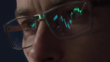 Parlayan borsa yansıması olan gözlük takan odaklanmış bir tüccarın yakın çekimi. Kripto yatırımcısı kripto para piyasasını analiz ediyor. Finans, ticaret ve yatırım kavramı.