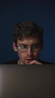 Gözlük takan heyecanlı, genç bir kripto tüccarı lenslerine yansıyan kripto para piyasası grafiklerine sevinçle bakıyor. Büyüyen borsa. Dikey video