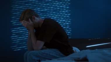 Geceleri yatak odasının karanlığında, bir adam yalnız oturur, yorgun ve düşüncelere dalmış. Depresyon, tükenme ve duygusal yorgunluk. Metin için boşluk