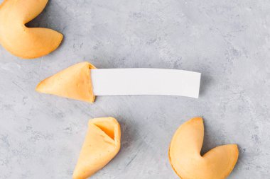 Nötr arkaplanda açık fal kurabiyesinin üst görünümü ve kopya alanı için boş bir kağıt parçasıyla