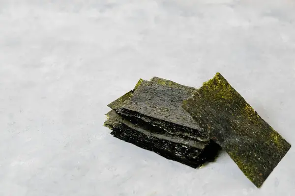 Nötr ışık arkaplanı üzerinde kopya alanı olan ev yapımı nori çipleri