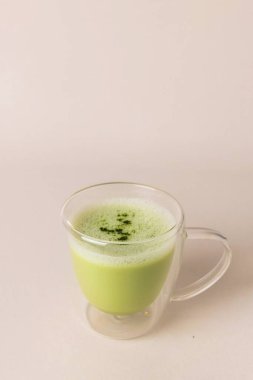 Hafif arka planda cam bardakta köpüklü kibrit latte, boşluğu kopyala