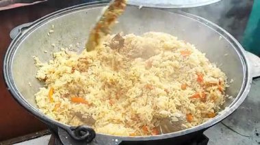 Özbek pilavı dışarıda büyük bir tencerede pişirildi. Yüksek kaliteli FullHD görüntüler