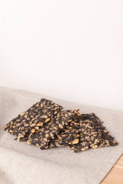 Crispy homemade crackers with seeds on light background clipart