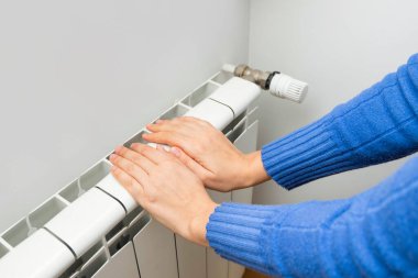 Eller evdeki modern radyatör termostatını ayarlıyor