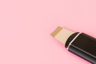 Pembe arka planda ultrasonik cilt temizleyici, kopyalama alanı, seçici odak