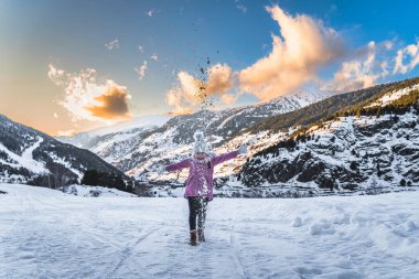 Young skier, girl having fun on the snow, throwing snow powder up. Winter ski holidays in Andorra, El Tarter, Pyrenees Mountains, Grandvalira