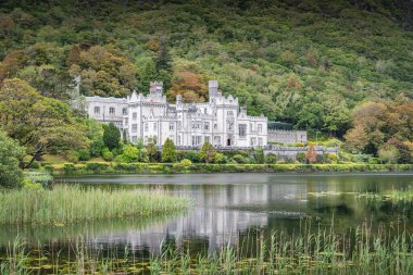 Kylemore Abbey, beautiful white castle reflected in lake at the foot of a mountain. Benedictine monastery founded in 1920, Connemara, Galway, Ireland