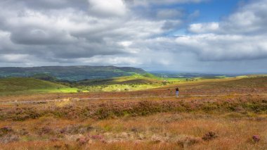 Tahta kaldırımda duran ve fotoğraf çeken bir kadın güzel Cuilcagh Dağı 'nın fotoğraflarını çekiyor. Fermanagh Bölgesi, Kuzey İrlanda.