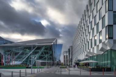 Dublin, İrlanda, 10 Ekim 2020 İnsanlar modern bina ve mimari ile çevrili Büyük Kanal Meydanı 'nda dinleniyor, yemek yiyor ve eğleniyorlar.