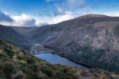 Glendalough gölü ve vadideki nehir. Dağ tepelerindeki orman. Güzel sonbahar Wicklow Dağlarında yürüyüş, İrlanda
