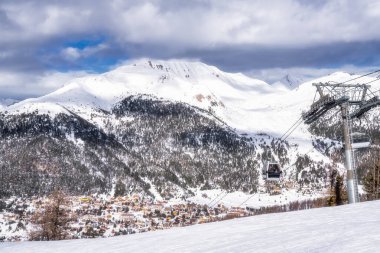Montgenevre kayak köyünün manzarası, kayak asansörü ve araba Fransa ve İtalya sınırındaki Cottian Alps 'e gidiyor. Dağlarda kış sporu