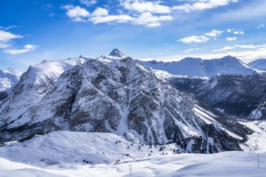 Yüksek, kayalık dağ zirvesi, dik kayalıklar, karla kaplı vadi ve orman, kış sporları, Montgenevre kayak köyü, Alpler, Fransa