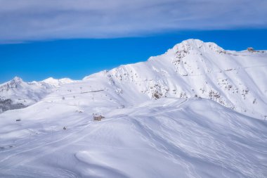 A breathtaking view features snowcovered peaks against a blue sky, illustrating winters beauty, making it the perfect backdrop for skiing and exploring, Montgenevre ski village, Alps, France clipart