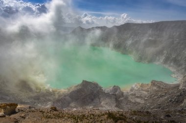 Büyüleyici bir turkuaz volkanik asit gölü ya da yanan sülfür birikintisinin dumanı Doğu Java, Ijen volkanı ve Endonezya 'nın altında.