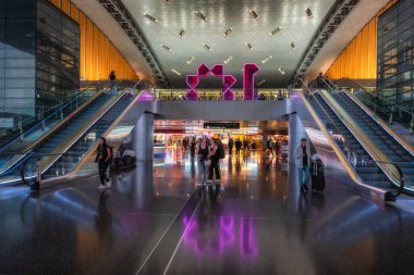 Doha, Qatar, 27 Sep 2024 A contemporary modern Hamad airport terminal filled with escalators, bright LED lights, and dynamic, lively travelers creates a vibrant and energetic atmosphere for all clipart