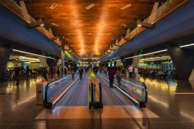 Doha, Qatar, 27 Sep 2024 A vibrant and bustling Hamad airport interior showcases contemporary design elements, glowing pathways, and a dynamic atmosphere filled with travelers on the go clipart