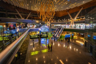 Doha, Katar, 27 Eylül 2024 Hamad havaalanı çarpıcı görselleri, harika ışıklandırmaları ve dükkanları olan modern mimariye sahip, gezgin deneyimlerini geliştiren canlı bir atmosfer yaratıyor.