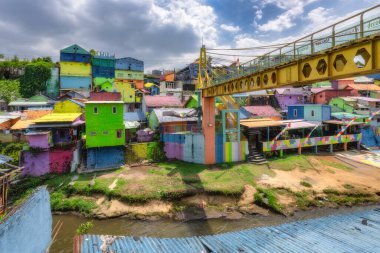 Malang, Java, Endonezya, 2 Ekim 2024 Renkli ve gelişen bir toplum atmosferi içinde canlı şehir sanatının sergilendiği nehir kıyısında parlak ve büyüleyici bir manzara.