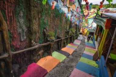 Malang, Java, Endonezya, 2 Ekim 2024 Keyifli bir şehir geçidinde, yemyeşil bir ortamda renkli adımlar göze çarpar.