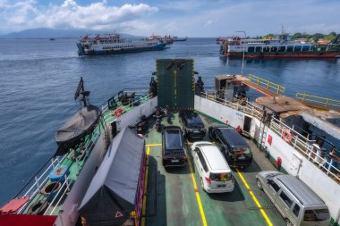 Bali, Indonesia, 4 Oct 2024 This captivating image provides a breathtaking view of a bustling harbor, showcasing the active transportation activities where cars and ferries coalesce on the water clipart