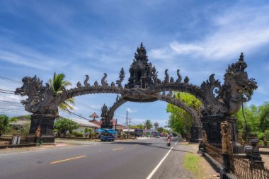 Bali, Endonezya, 4 Ekim 2024 Bali 'nin unutulmaz güzelliğine kendinizi daldırın, burada karmaşık bir şekilde tasarlanmış taş kemer çarpıcı bir gökyüzüne karşı zengin geleneksel mimariyi sergiliyor.