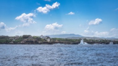 The stunning coastal landscape showcases vibrant green hills, calm serene waters and bright blue sky leisurely dotted with fluffy white clouds. It feels like paradise, Nusa Lembongan, Bali, Indonesia clipart