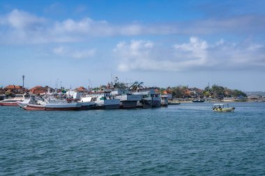 Bali, Endonezya, 06.10.25 nefes kesen resimli liman manzarası berrak mavi sularda demirlemiş bir tekne koleksiyonunu sergiliyor, hepsi parlak, güneşli bir gökyüzünün altında.