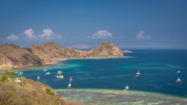 Berrak bir gökyüzü altında turkuvaz suları ve renkli tekneleri olan büyüleyici kayalık adaların tadını çıkarın. Rahatlama ve macera arayan doğa severler için mükemmel bir kaçış yolu. Labuan Bajo, Komodo, Endonezya