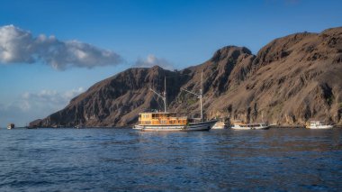 Dramatik uçurumlara karşı lüks yatların, Catalina Adalarının çarpıcı kıyı şeridinin ve doğal güzelliğin, seyahat meraklıları, Komodo takımadaları, Endonezya için ideal güzelliğin tadını çıkarın.